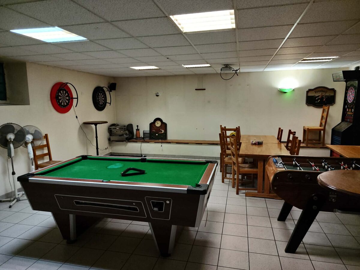 Salle de jeux du Presstabar avec billard, baby-foot et flechettes